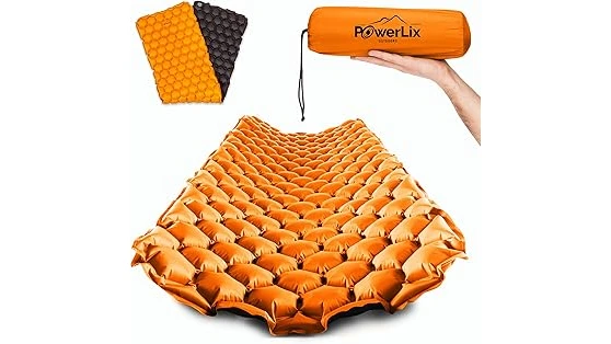 The image shows a cozy campsite scene with a rolled-up backpacking mattress ideal for the best 31 backpacking mattress list.